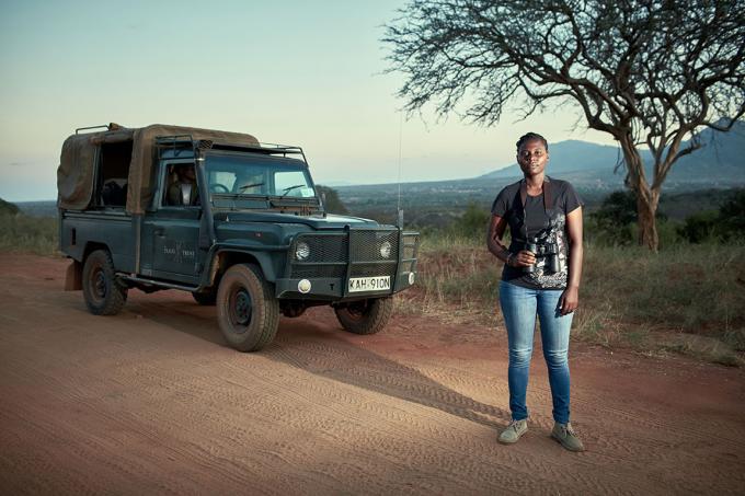 Une volontaire de patrouille anti-braconnage en jeep dans la savane africaine à la tombée de la nuit